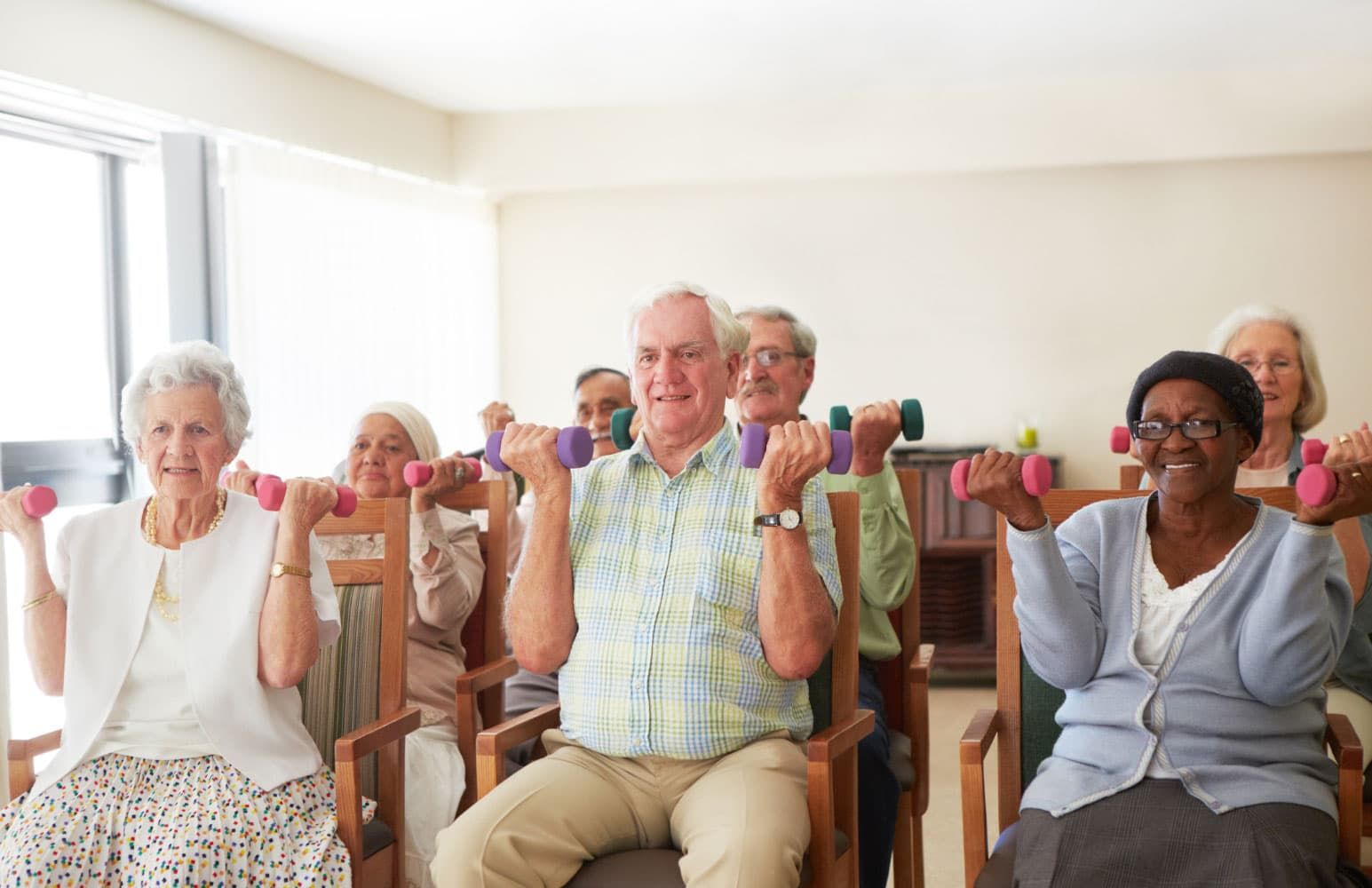 senior adults lifting weights in a group class at their senior living community