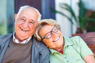 image of a senior man and senior woman leaning into each other smiling happily