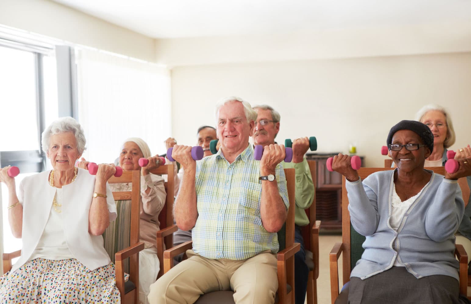 senior adults lifting weights in a group class at their senior living community